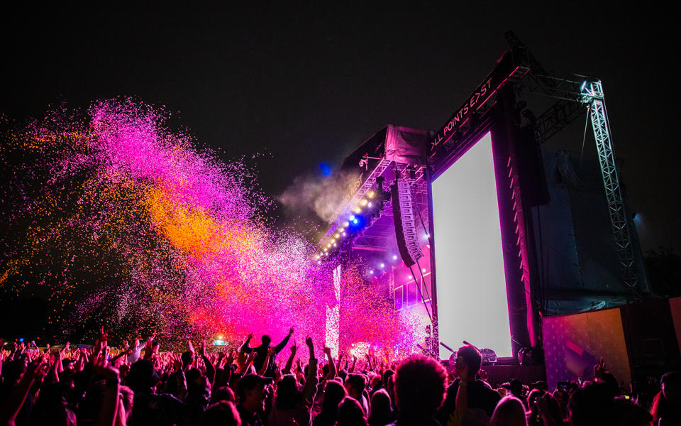 Bombay Bicycle Club on stage at All Points East. A huge plume of colour and light showers the crowd beneath